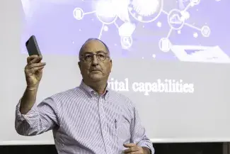 Fred Turner tenant un téléphone dans la main